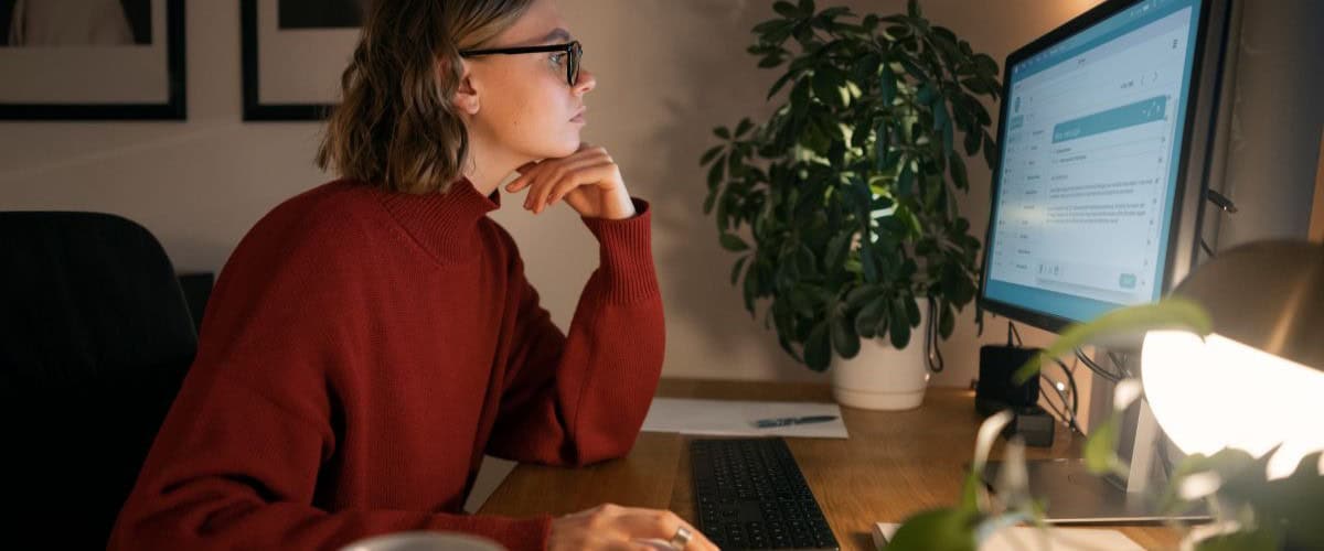 software de trabalho híbrido - mulher em frente ao computador analisando um software