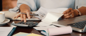 uma mulher com calculadora e papéis na mão para calcular taxa de ocupação do escritório